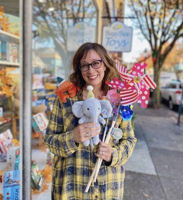 Busy Bee Toys owner, Nerice Kendter standing outside of her toy store holding toys.