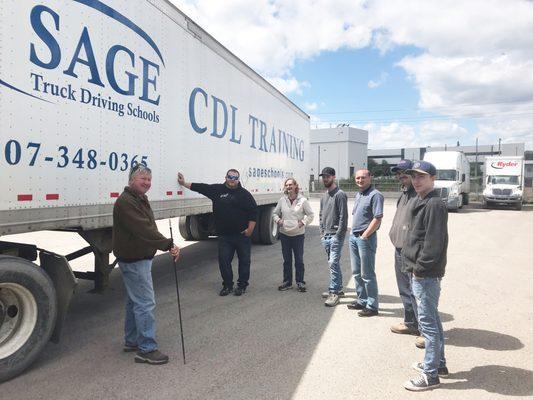 instructor teaching Sage students on the driving range.