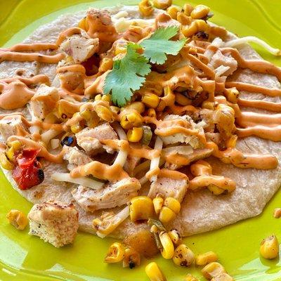 Chipotle chicken taco made with grilled breast of chicken, fire-roasted corn, Monterrey jack cheese & Chipotle aioli on a freshly made flour