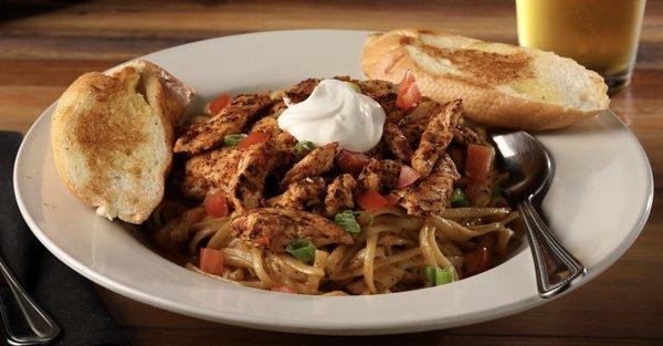 Linguine pasta tossed in our cajun cream sauce, topped with sour cream, chives, tomatoes, and garlic bread.