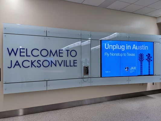 Welcome to Jacksonville sign near the rental car agency counters.