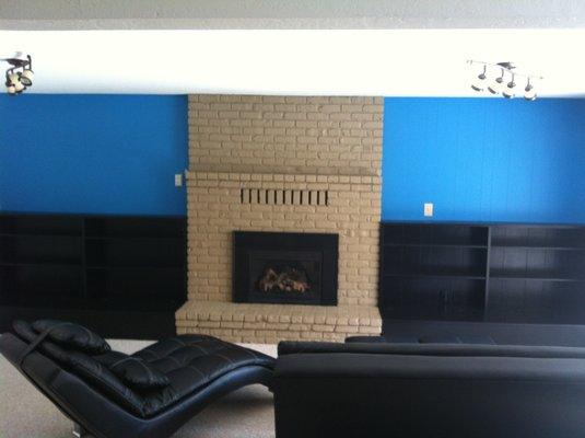 Black cabs. Blue accent walls. Tan fireplace.