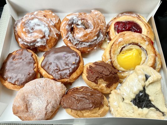 Cinnamon roll donuts, choc-glazed custard donuts (Boston cream), apple donut, Danishes, eclairs, poppyseed cookie