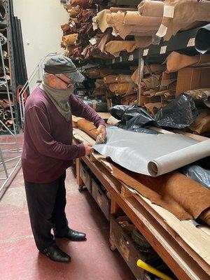 Larry of S.H. Frank cutting a leather sample for a designer