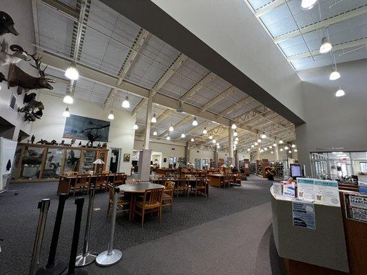 Main library section with front desk and communal tables.