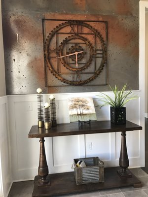 Entrance to a Clubhouse featuring:  Rustic Metal Walls, Large scale antique clock, custom console table, unique accessories.