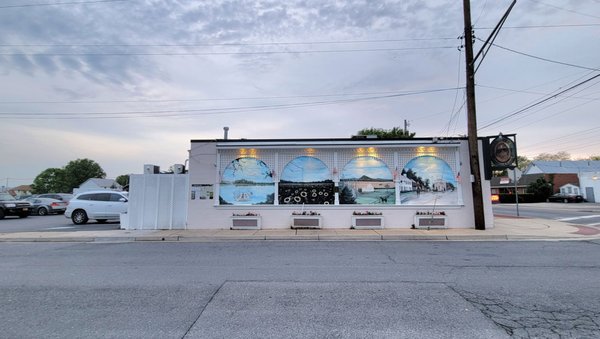 The side of the restaurant. The parking lot is at the back of the restaurant. There is outdoor seating in the back.