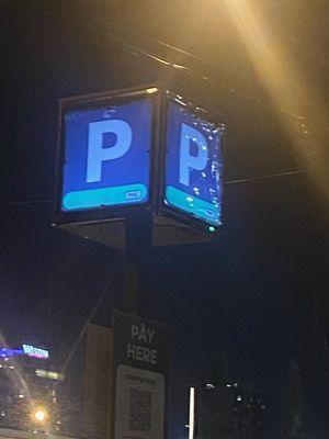 Sign on a Pole used for direction, Pay station location, and more