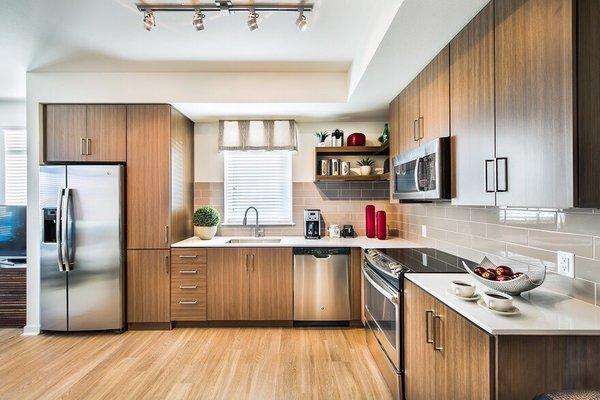 Kitchen area of apartment, beautiful appliances and sleek cooking area