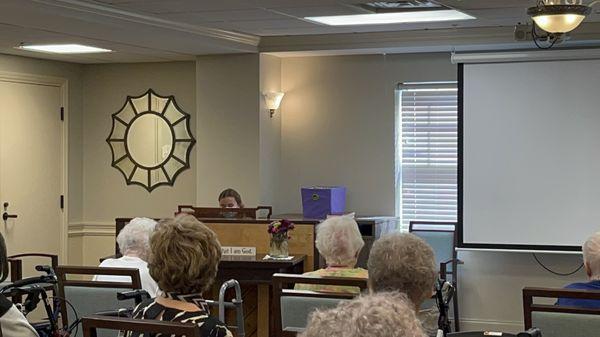 Activity room with students playing piano for residents