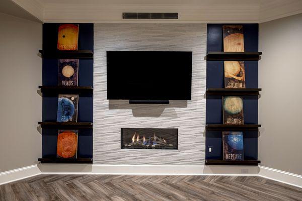 This complete basement renovation includes a Game Room with a sleek gas fireplace.