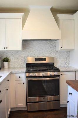 New marble countertop, back splash, and custom range hood