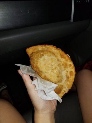 Beef empanada with sister's hand for size comparison