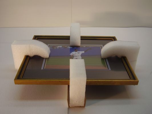 1- Place foam edge guards in the middle of all four sides of the frame.