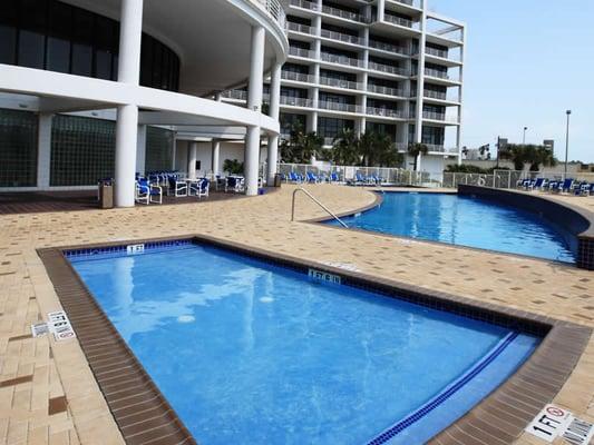 Heated pool with cascading fountains, children's pool and hot tub located at the base of the Sunchase IV building.