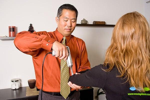 Dr. Park does a chiropractic adjustment with an activator