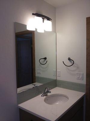 Frame-less mirror, glued to wall and sitting on the backsplash. Hilton Glass and Door 208-263-3322