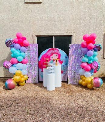 Chiara shimmer wall, round backdrop, balloon garlands and white pedestal tables with cake stands