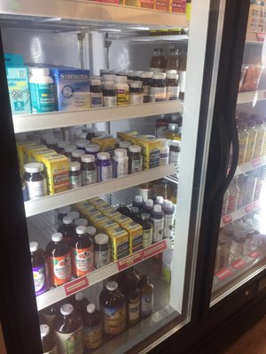 The refrigerator case is full of probiotic supplements and kombucha.