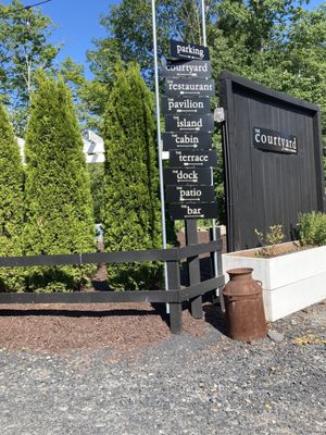 Entrance to courtyard and sign showing directions to all the amazing features Third and Company Lakeside Restaurant has to offer