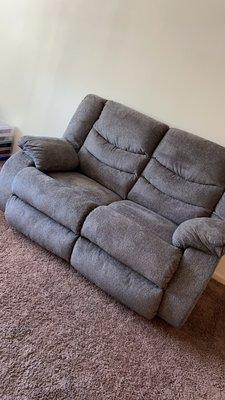 A grey recliner loveseat