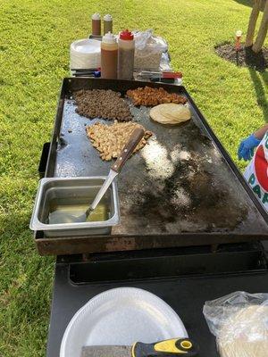 Tacos being prepared in a backyard.