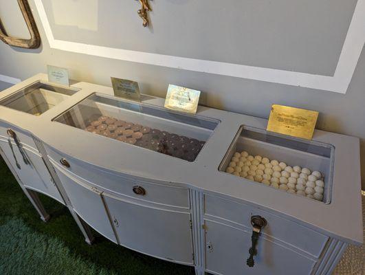 Inside. Self-serve chocolates stored in antique furniture. In this case, a chest with drawers (glass top) and cabinets.