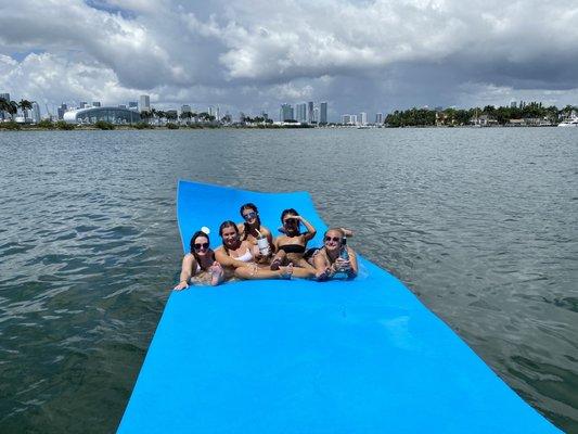 On his floating mat, with Miami in close view