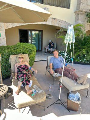 Clients receiving IVs around a hotel pool