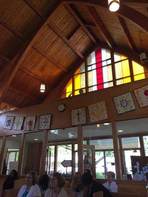 A small person watches the service from the balcony.