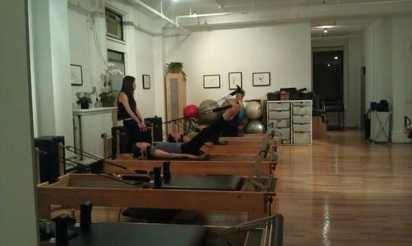 Group class at 7:30pm on a Monday; only 3 of 5 reformer machines are being used.