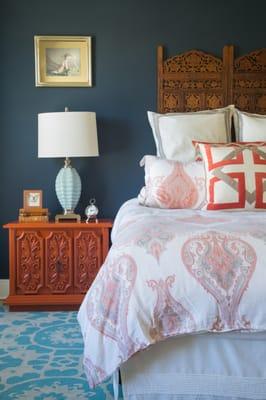 Master bedroom with Balinese headboard, vintage nightstands, navy wall and modern art, wool Morrocan design rug