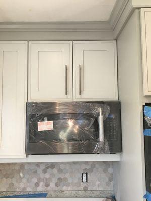 Two tone light gray cabinetry with crown molding.