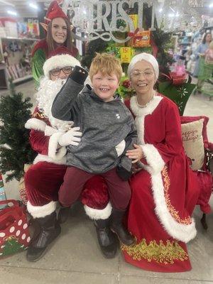 My 6yr old grandson with Santa and Mrs Clause, along with a helpful Elf!