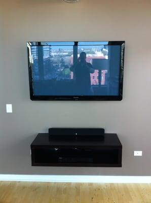 TV on wall with a wall mounted floating shelf!