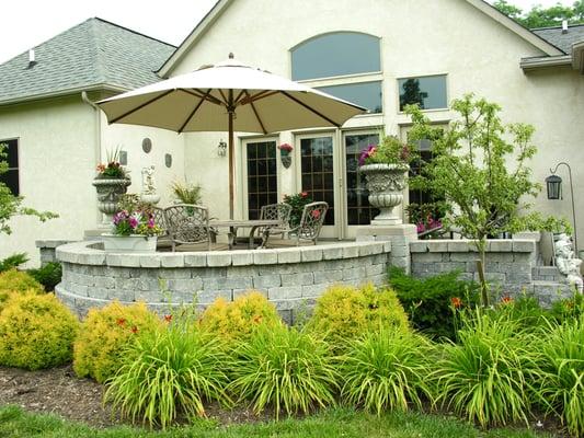 Raised patio including seatwalla, pillars, urns and plantings.