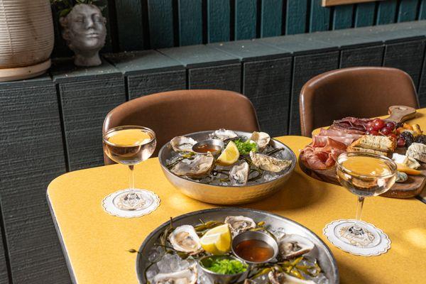 Oysters, Combo Board, and Champagne in our closed outdoor area, The Green Room.