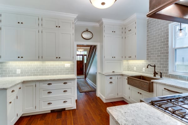 Kitchen looking down hall way to beautiful new front door with side lights and transom light over top