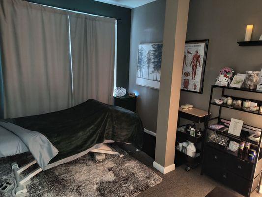 massage room.  left of photo: massage table right of photo: essential oils, candles, etc.