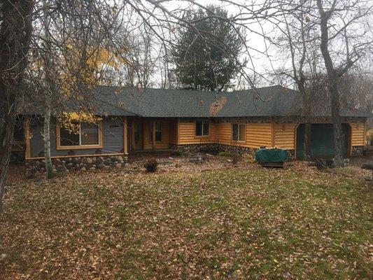 Installing new log siding and river rock.