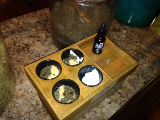 Exfoliating herbs, scrub, mask, and lotion set up for a relaxing Spa Pedicure.