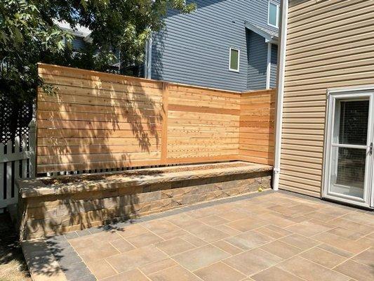 Paver patio, raised stone garden surrounded by horizontal board, solid cedar, wood fence in Walton, NE.