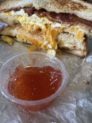 Bacon breakfast sandwich on sourdough with a side of local Alabama Sunshine spicy strawberry jam!