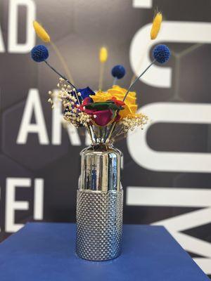 Trio Rose Arrangement in Silver Vase. Blue, Yellow and Rainbow preserved roses embellished with decorative flowers.