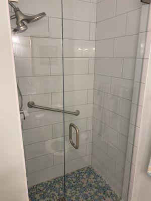 Guest bath. Tiny frosted glass door removed. New tile and glass door.