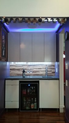 Bar after with concrete counter and integrated sink and color changing LED accent lighting.