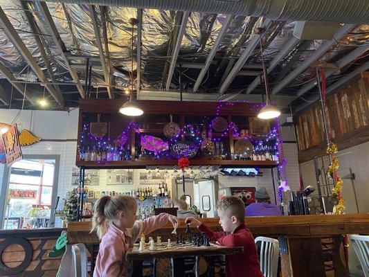 Kids playing chess by the bar. Smart!