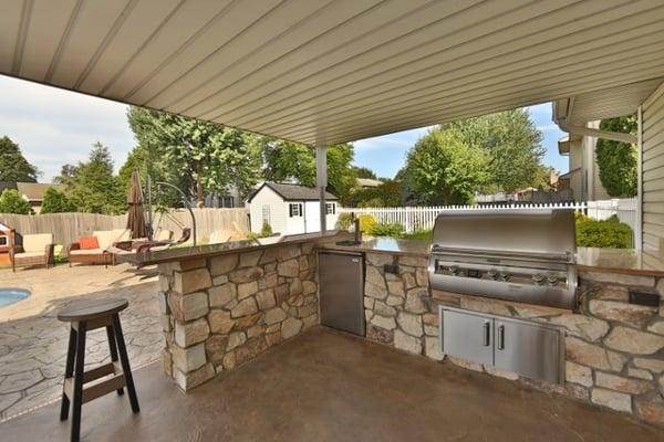 An customized, covered outdoor kitchen right when you walk out your patio door is convenient and great for winter time cooking.