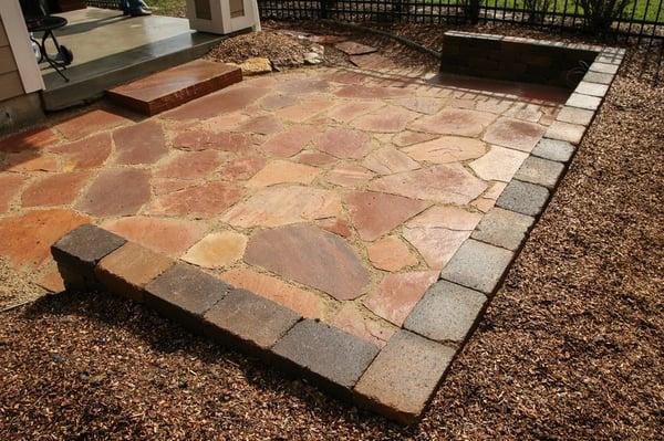 Sunken flagstone patio with seating wall.