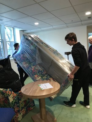 Mark and Andris moving a stretch wrapped loveseat into our client's new home.